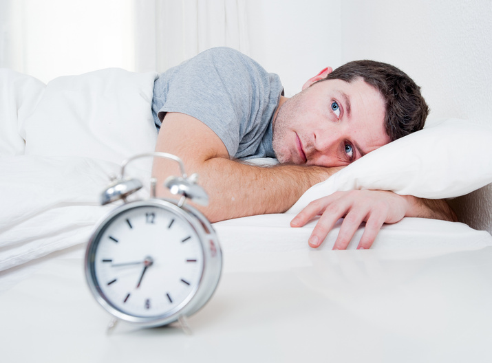 Image of a man laying in bed unable to sleep